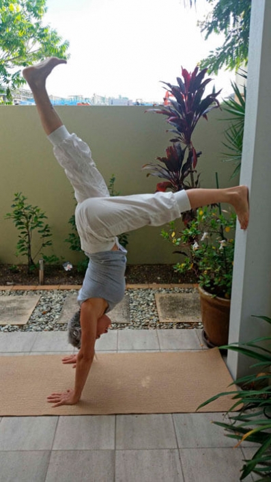 Kim Stansfield doing a hand stand against a wall